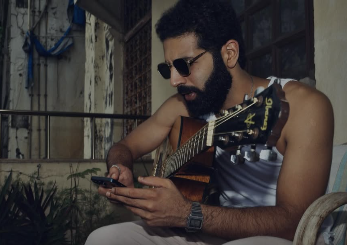 Azamaan with guitar checking phone